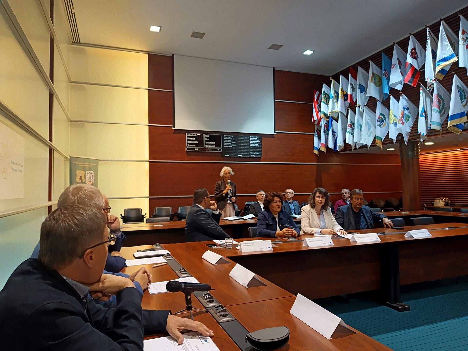 Szakmai munkacsoporti egyeztetés konferenciateremben, résztvevők tárgyalóasztal körül