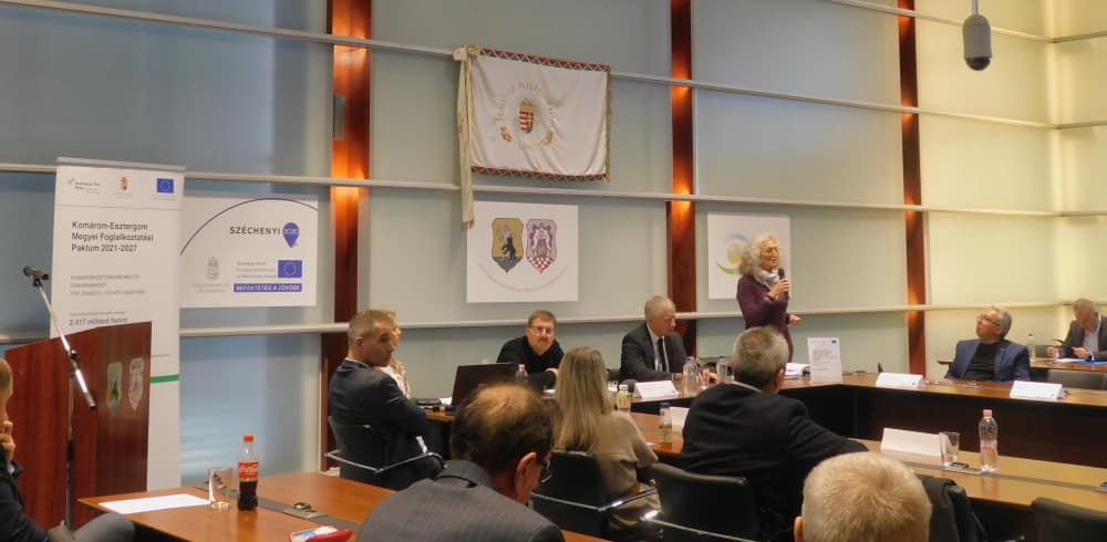 Résztvevők figyelik az elnökségi asztalnál zajló megbeszélést.
