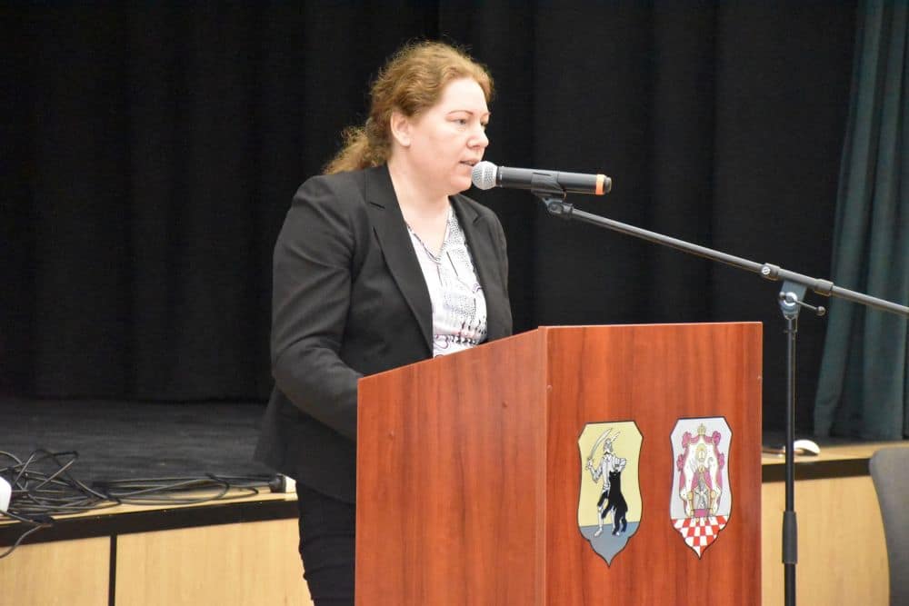 Előadó tart köszöntőt a Foglalkoztatási Paktum rendezvényén, pódiumról beszélve.