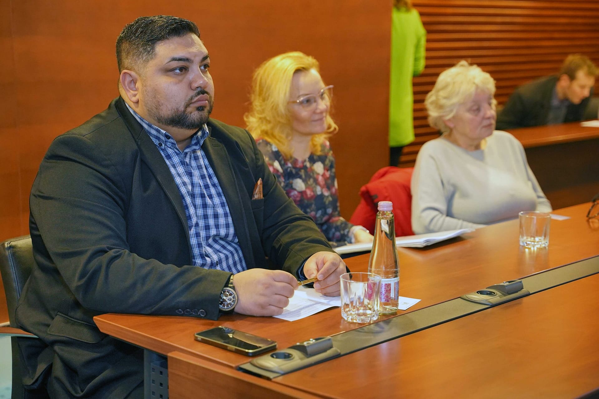 Résztvevők figyelik az elnökségi asztalnál zajló megbeszélést.