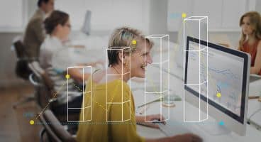 középkorú nő ül a számítógép előtt és diagramokat elemez